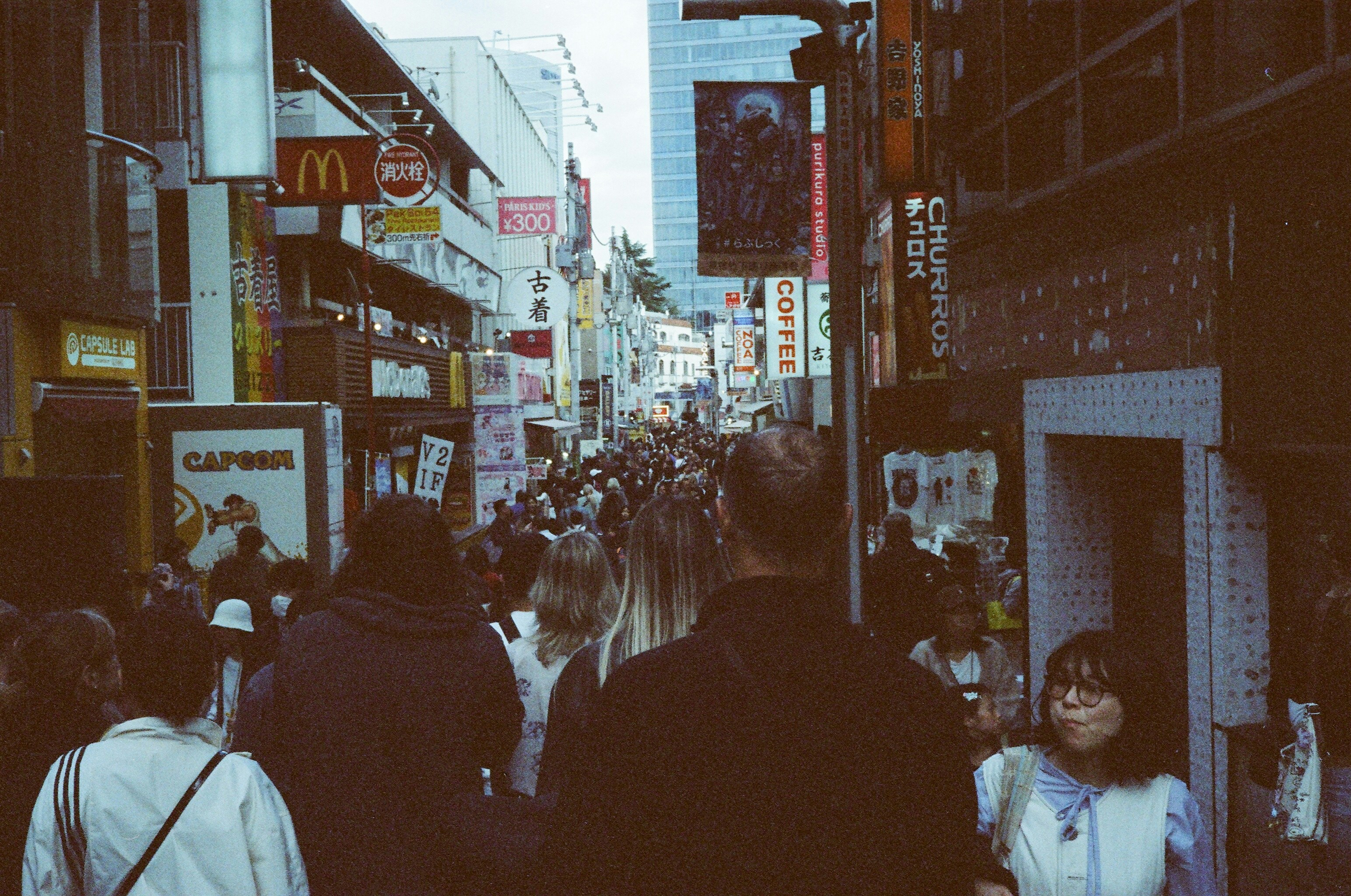 Crowded street with many people and signs.