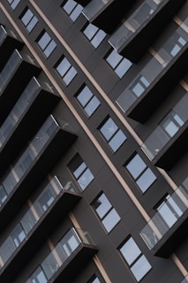Modern building facade with repeating balconies and windows.