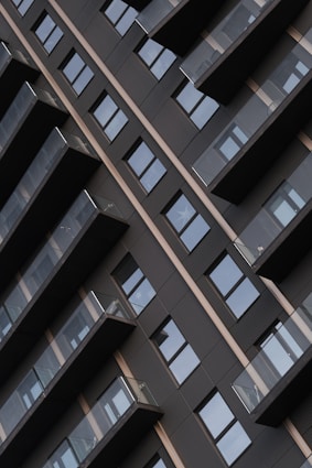 Modern building facade with repeating balconies and windows.