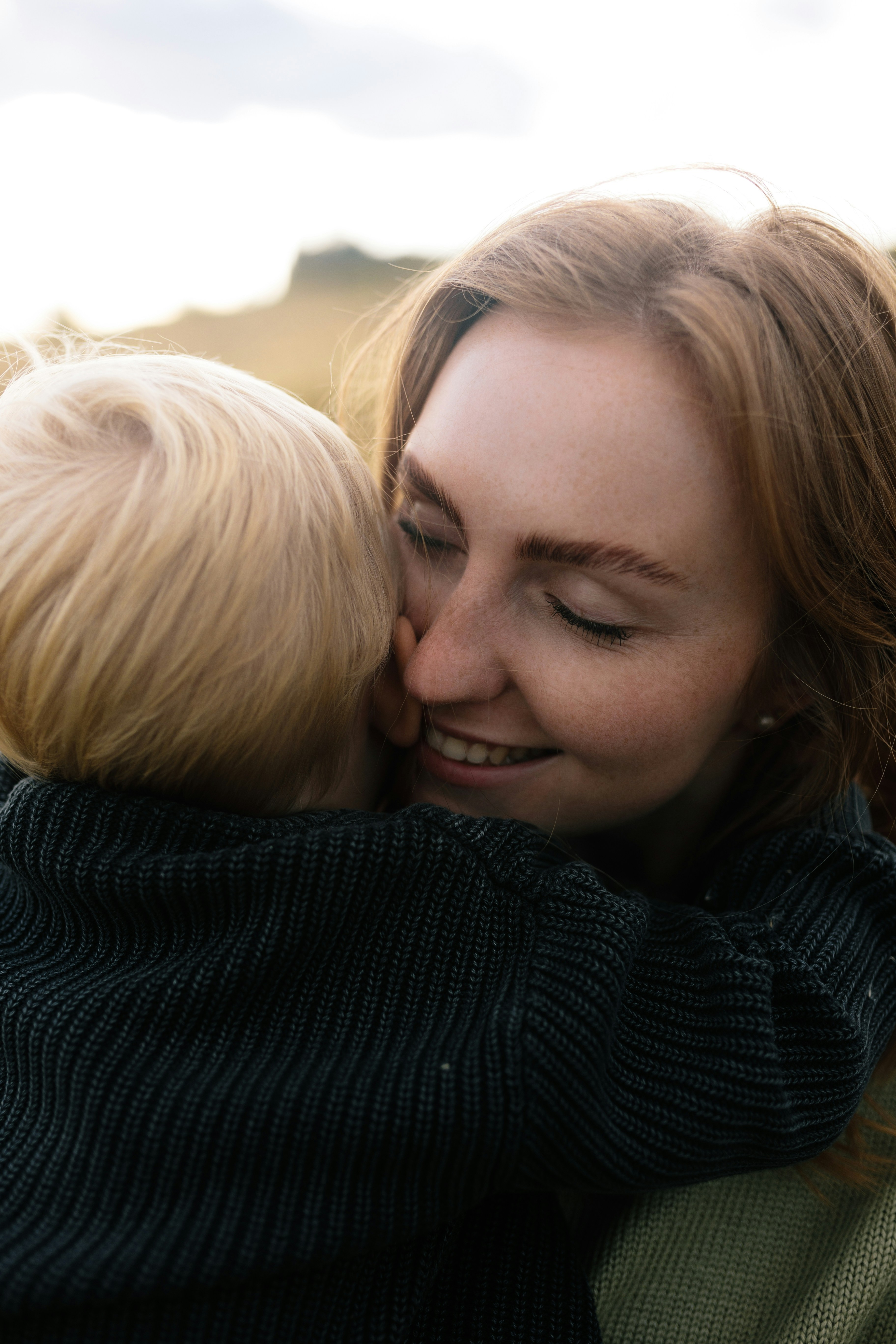 Mother hugging her young child outdoors