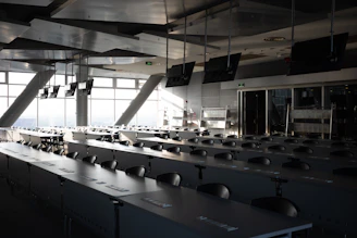 Rows of empty desks in a modern conference room.