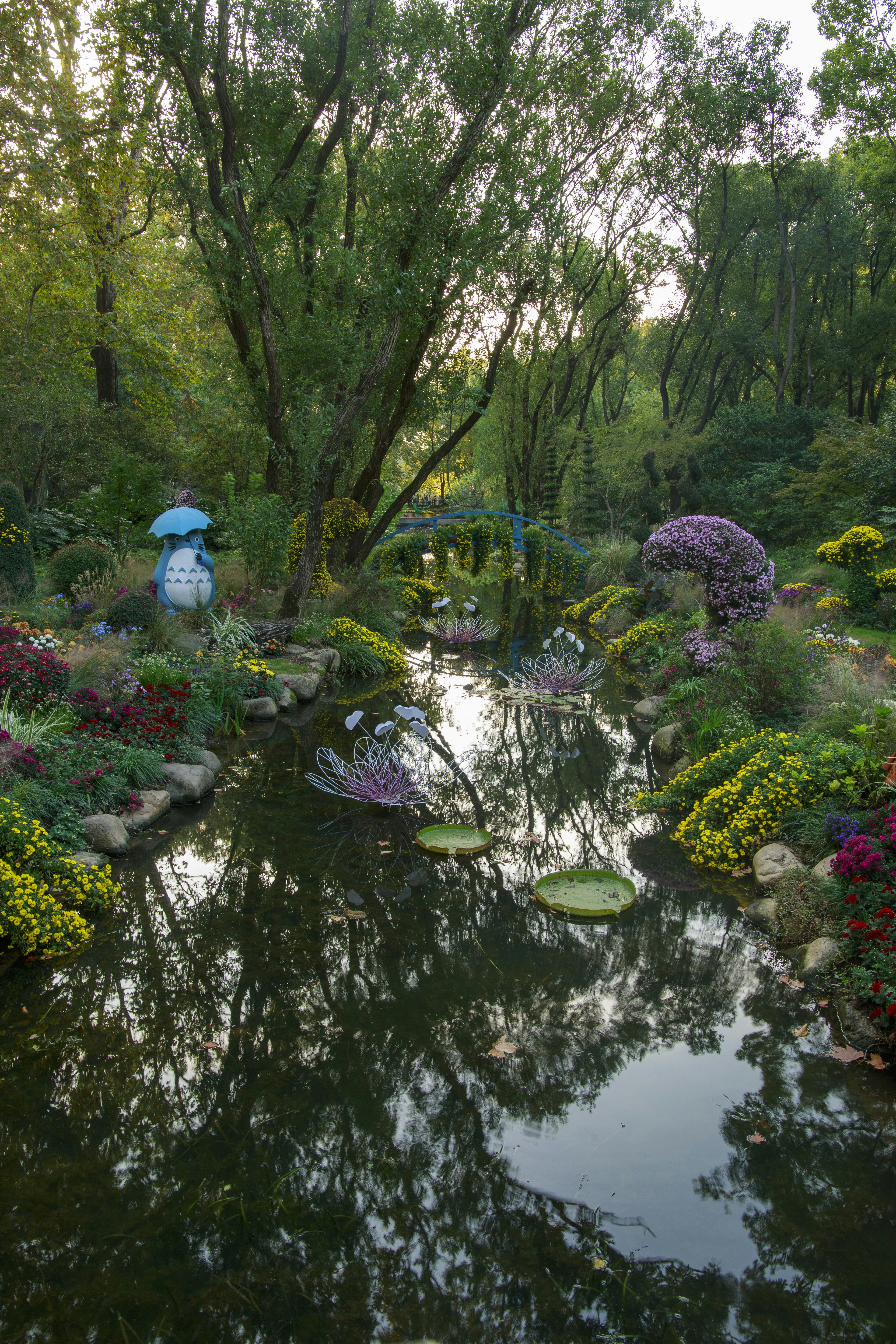 A tranquil garden with a stream and lush greenery.