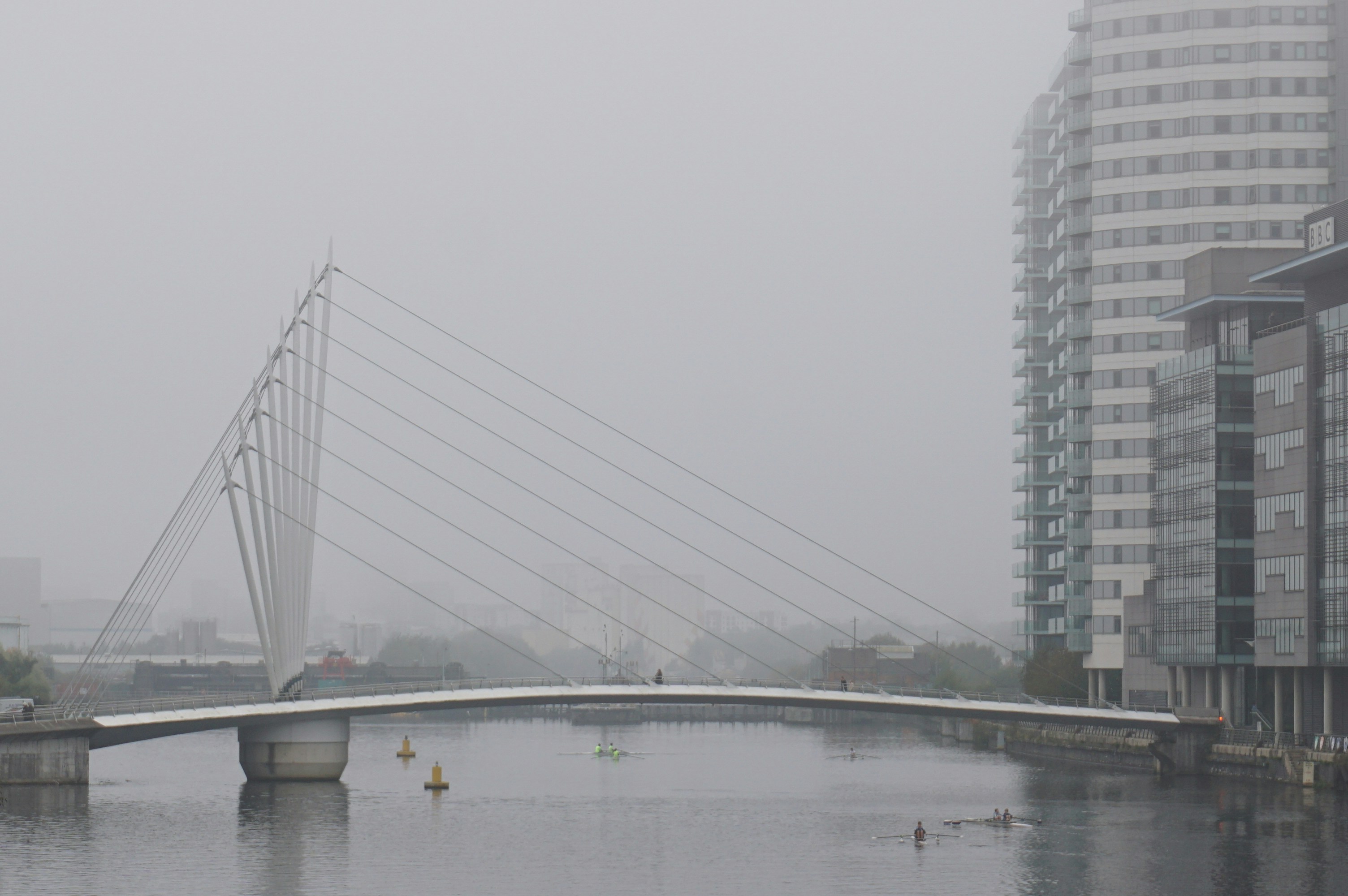A bridge over a river disappearing into morning mist