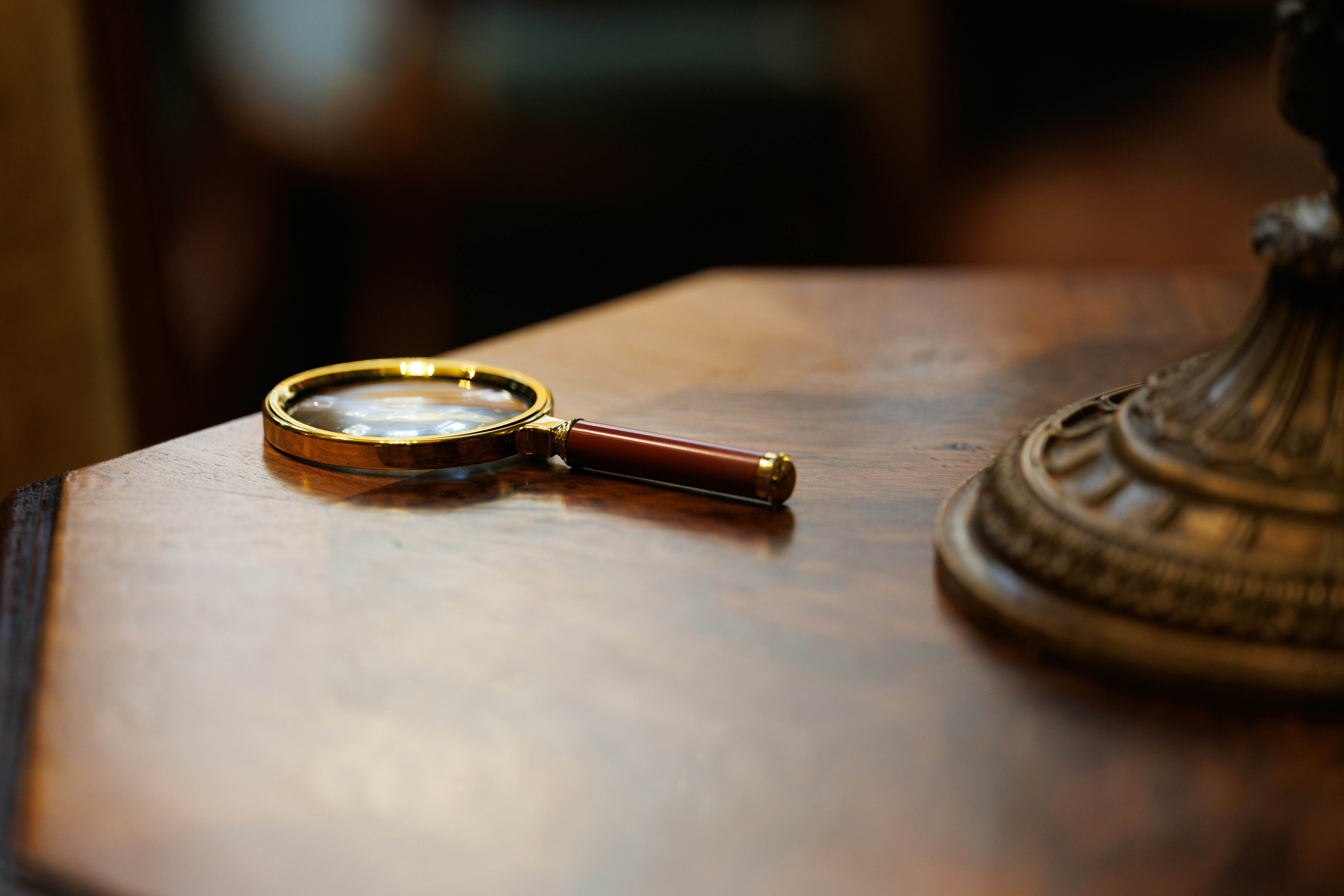 Vintage magnifying glass on wooden surface