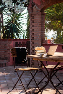 Laptop and coffee on a rustic outdoor table