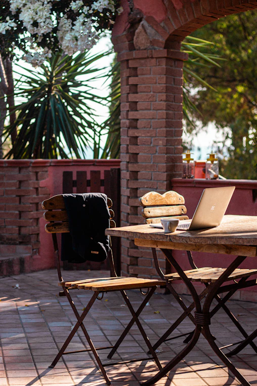 Laptop and coffee on a rustic outdoor table
