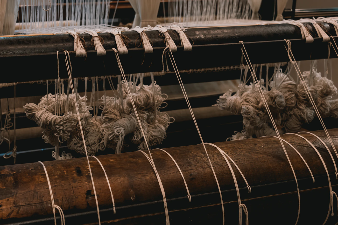 Yarn wound along a loom beam, with warp threads running toward the reed
