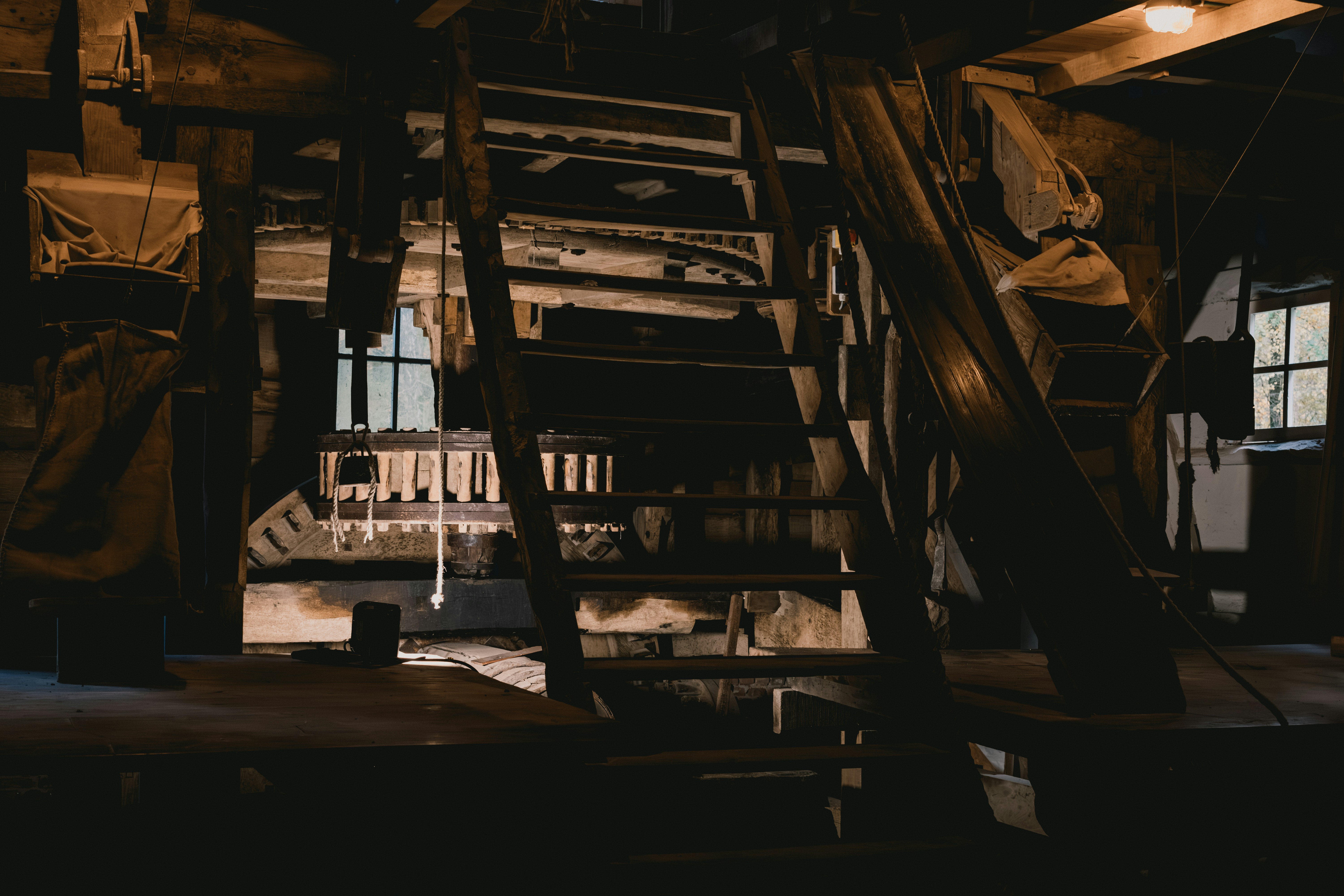 Rustic wooden interior with stairs and windows.