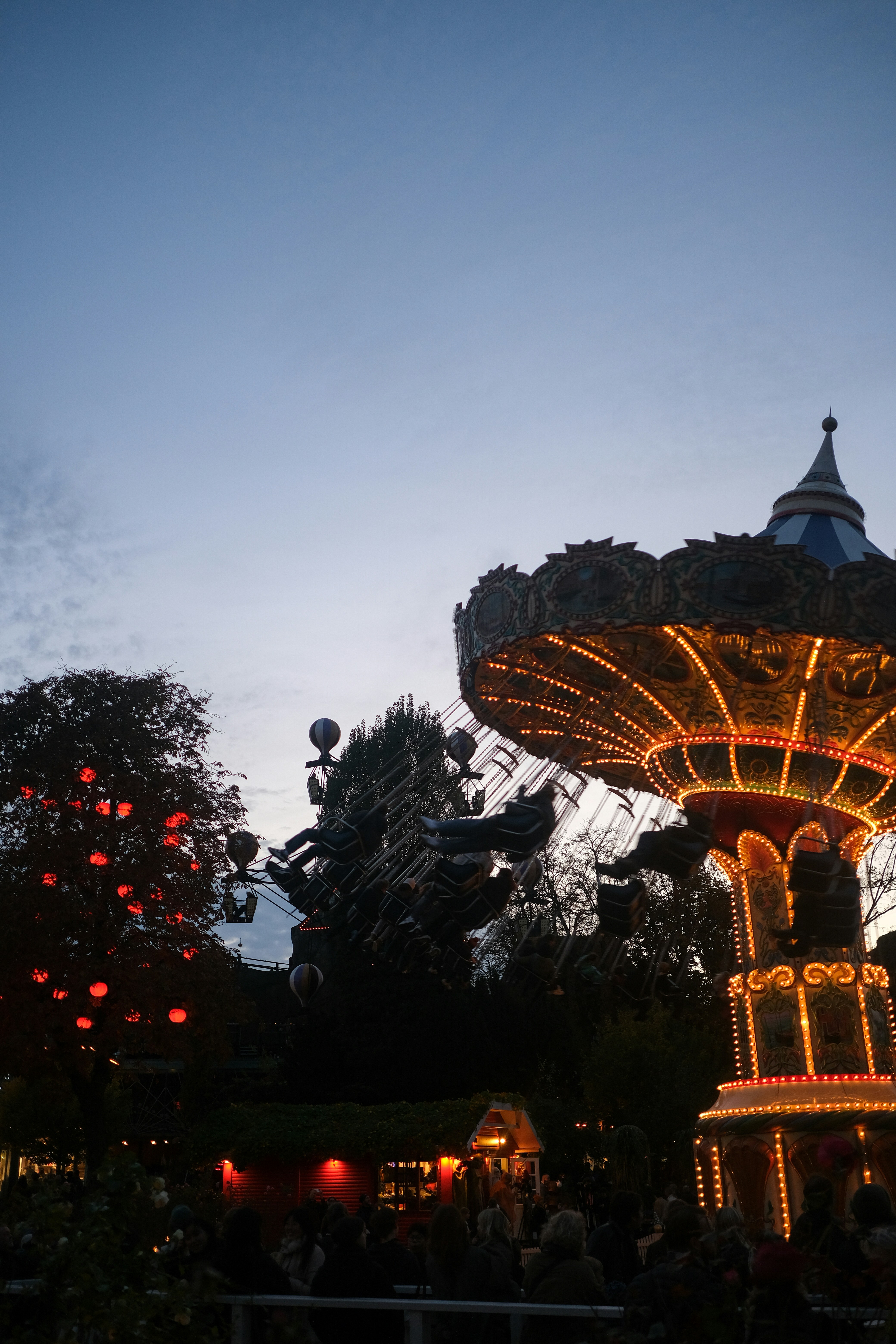 Amusement park carousel and rides at dusk.