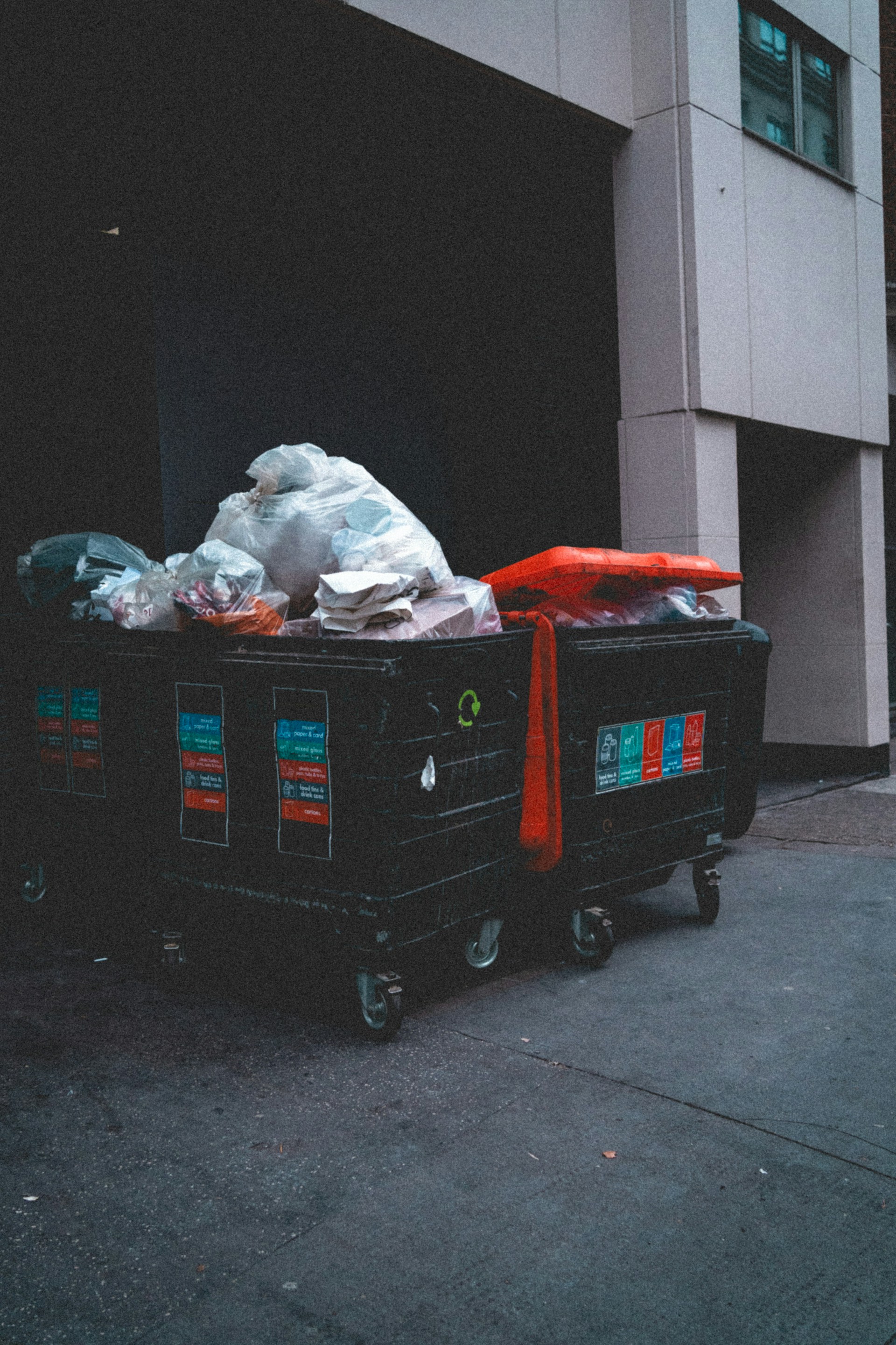 Overflowing trash bins outside a building