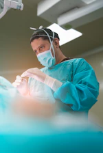 Surgeon performing a procedure in an operating room.