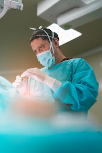 Surgeon performing a procedure in an operating room.