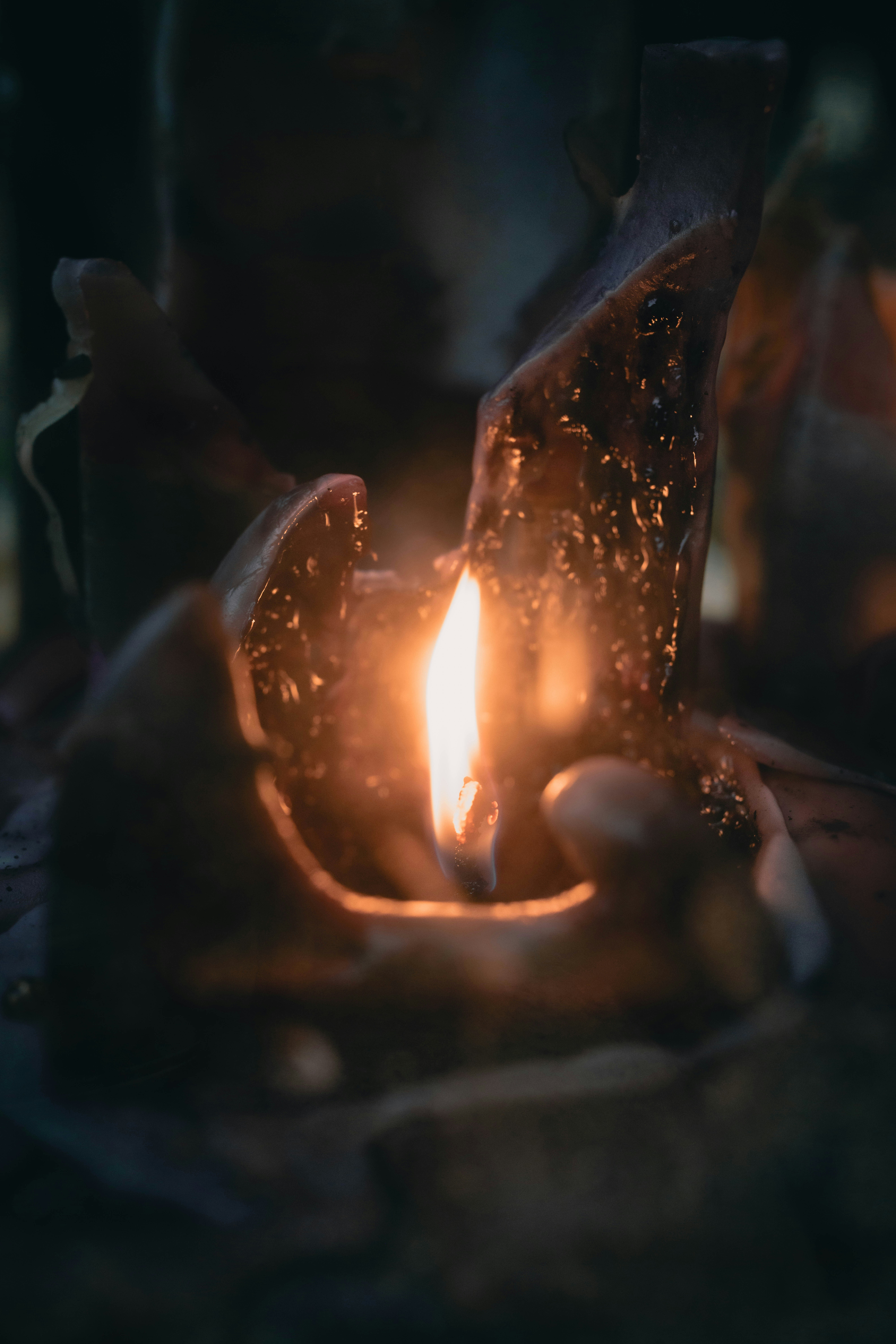 A burning candle with melted wax