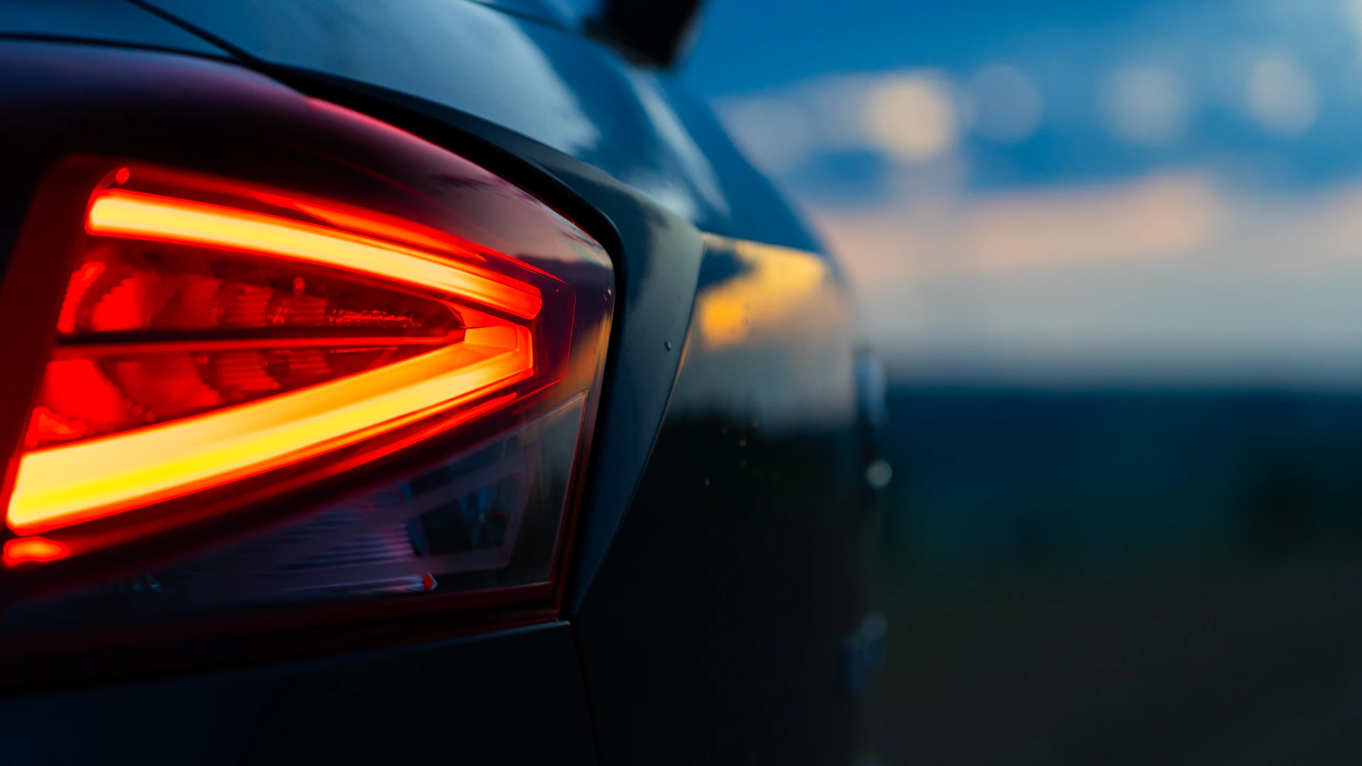Close-up of a glowing car taillight at dusk
