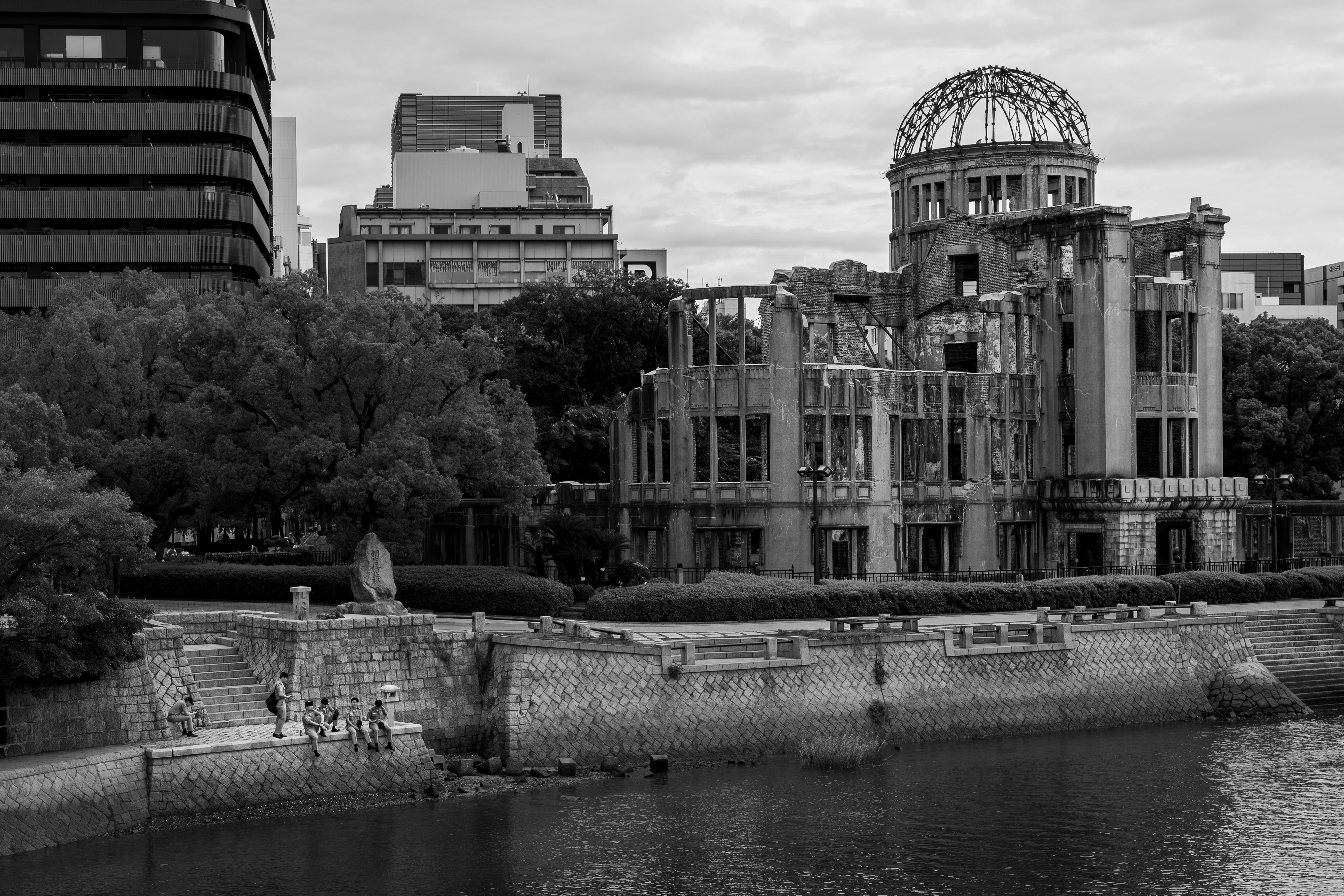 Ruined dome building by river with people