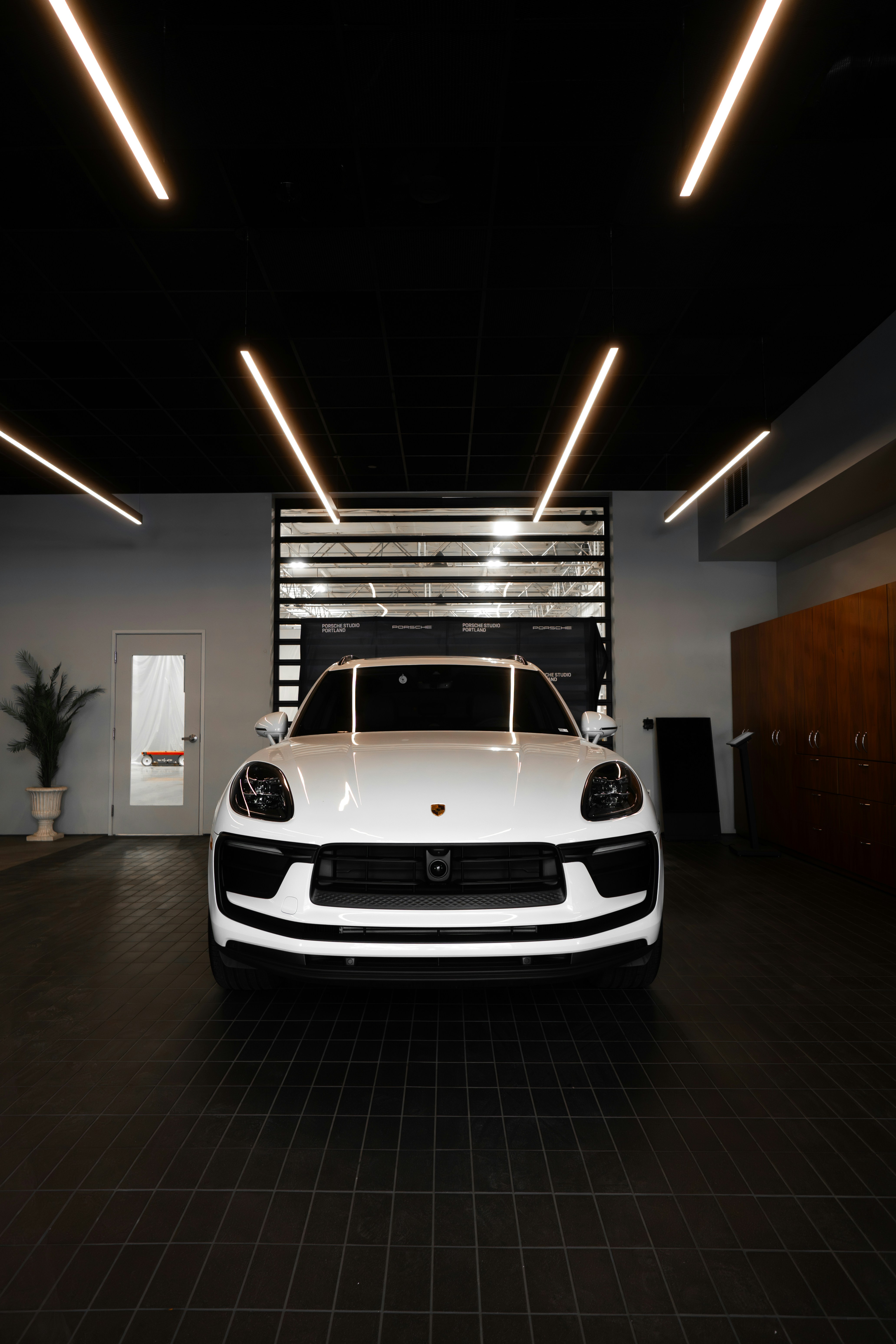 White porsche suv parked inside a modern showroom