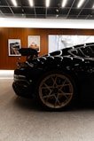 Black sports car with gold wheels in showroom