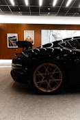 Black sports car with gold wheels in showroom