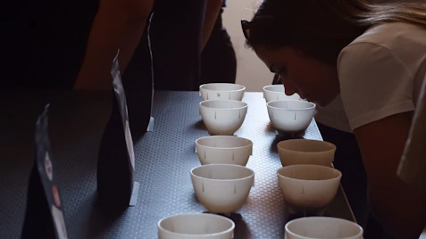 People smelling samples in small white cups