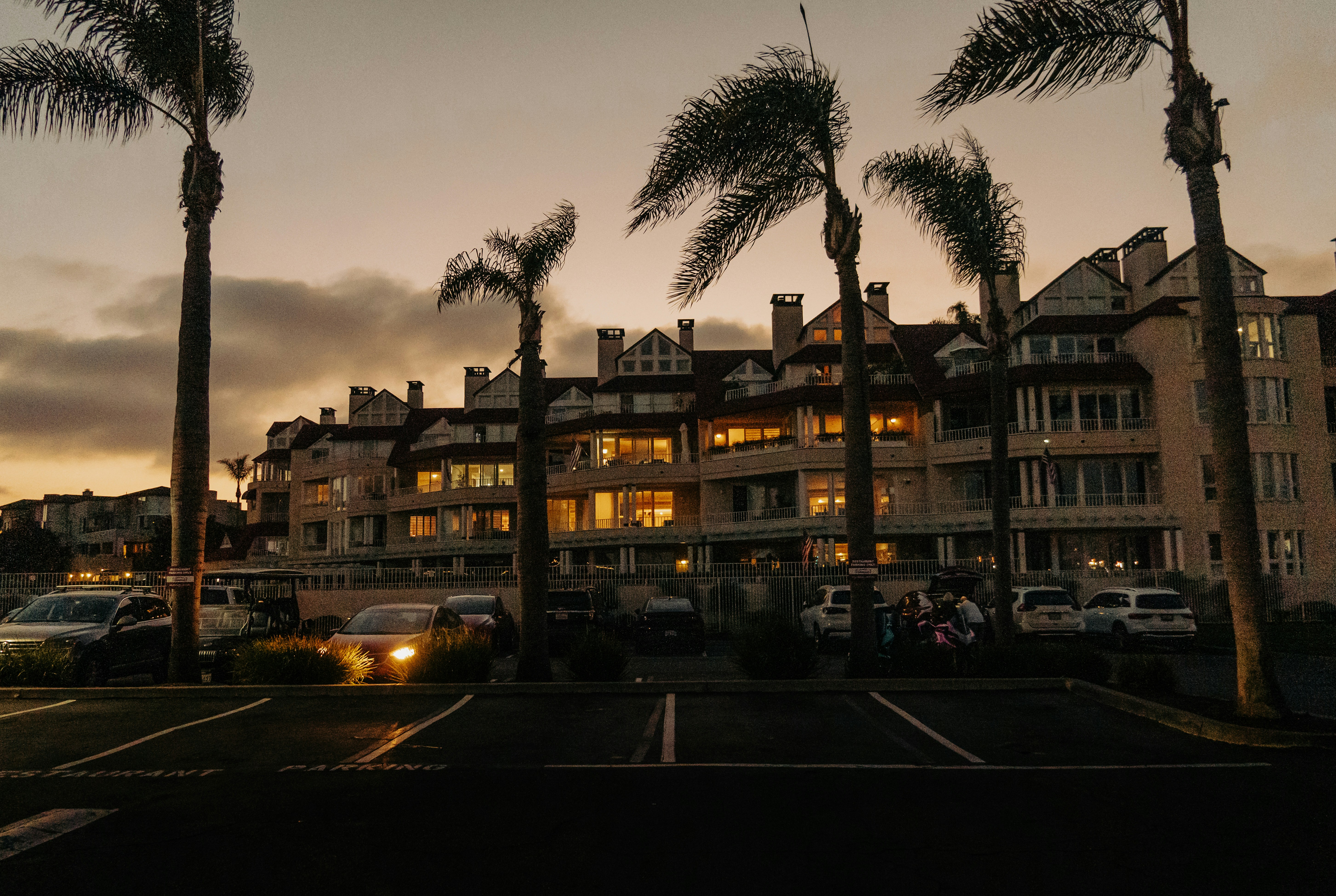 Apartment buildings with palm trees at sunset.