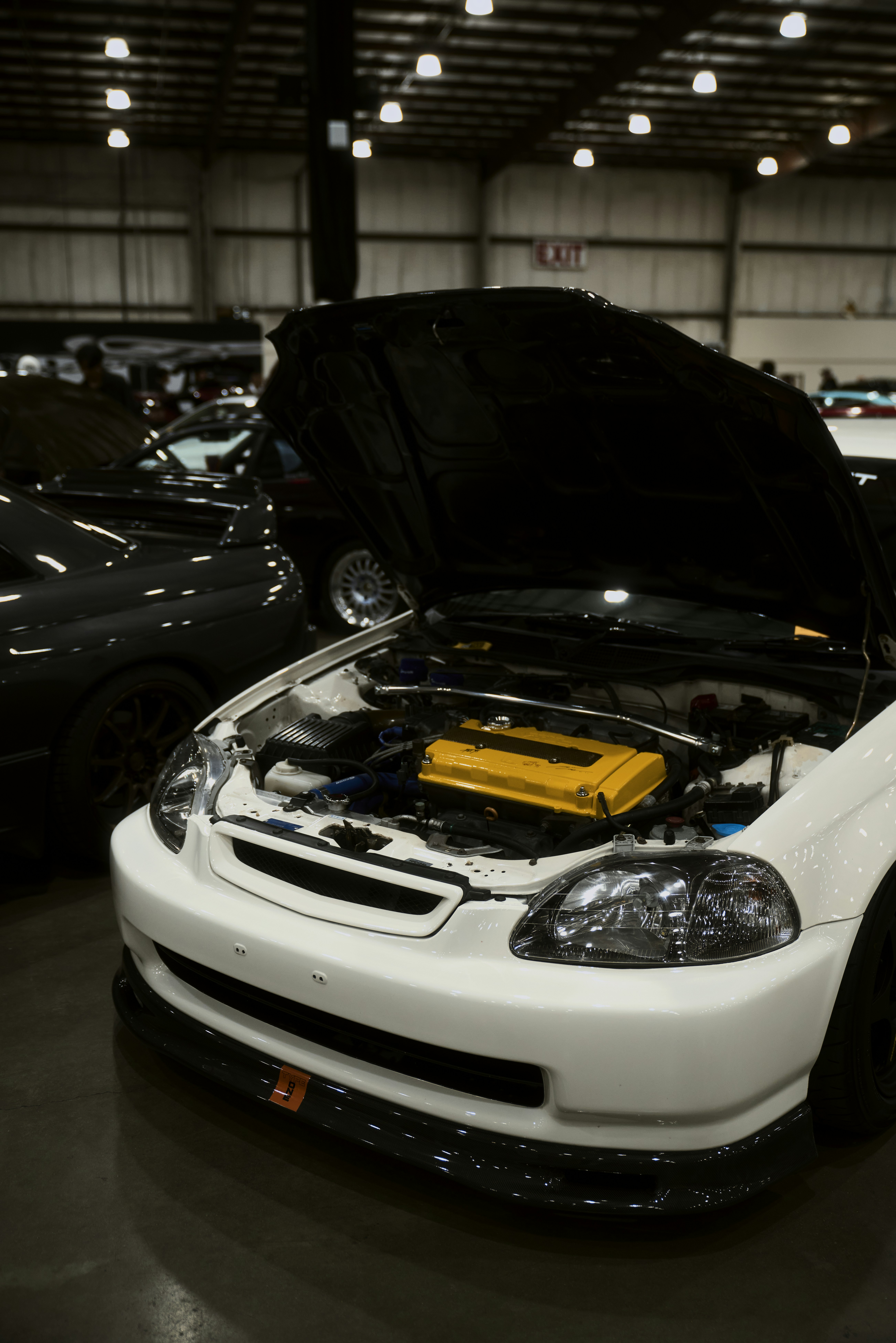 White car with hood open showing engine
