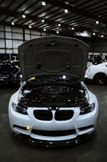 White sports car with hood open showing engine