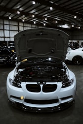 White sports car with hood open showing engine