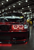 Red car with glowing red headlights at night.
