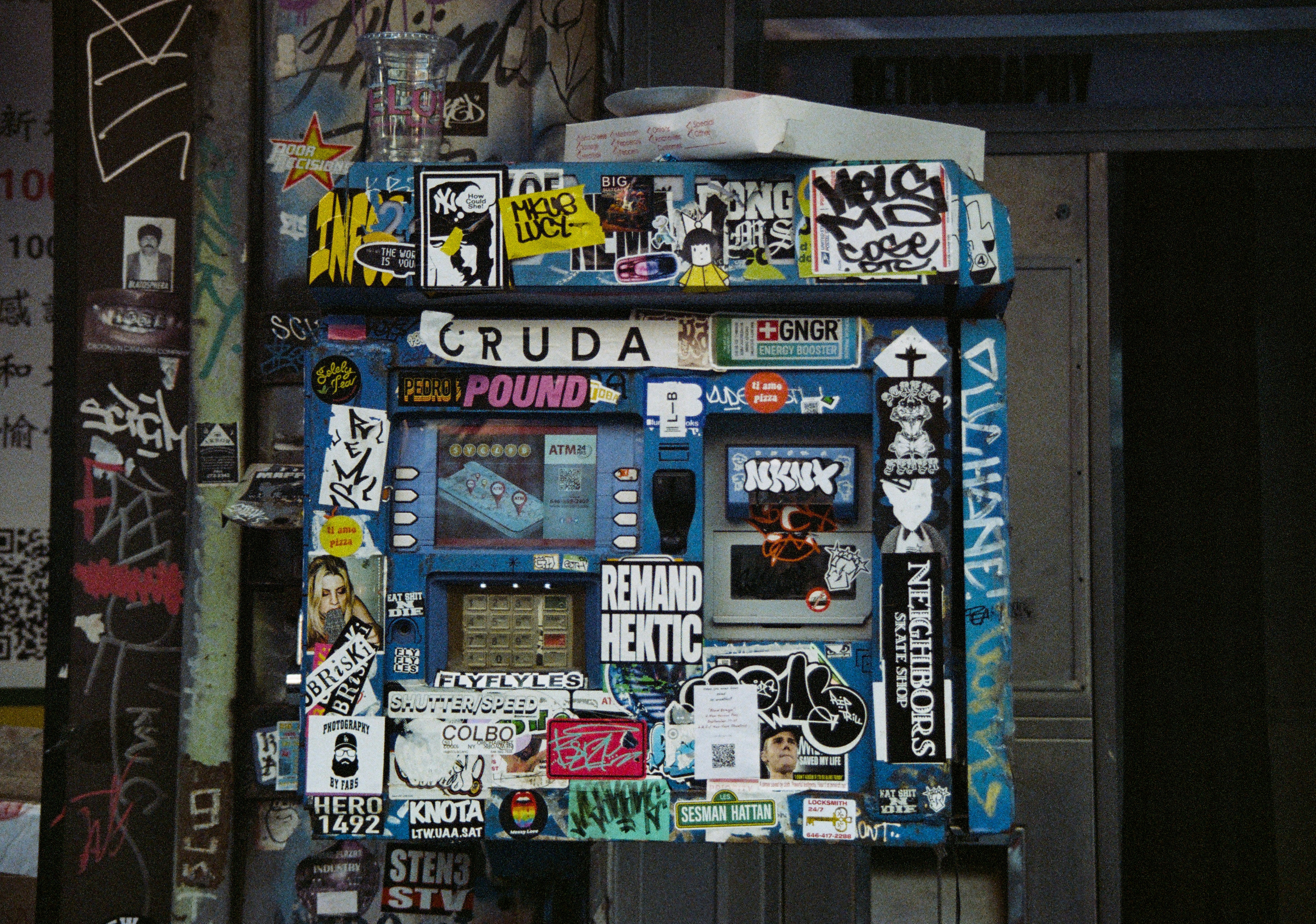 Vending machine covered in stickers and graffiti