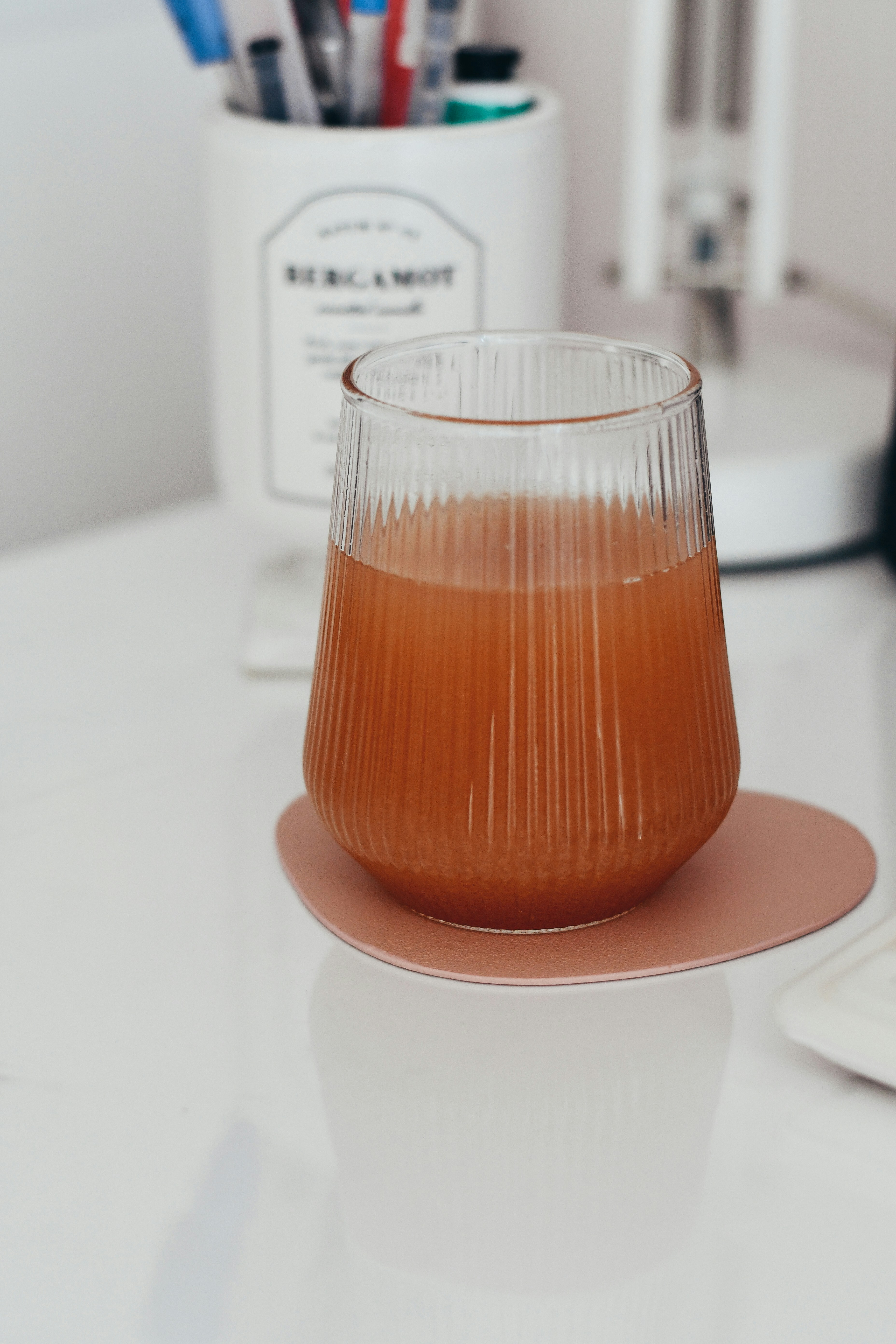 Glass of amber liquid on a pink coaster