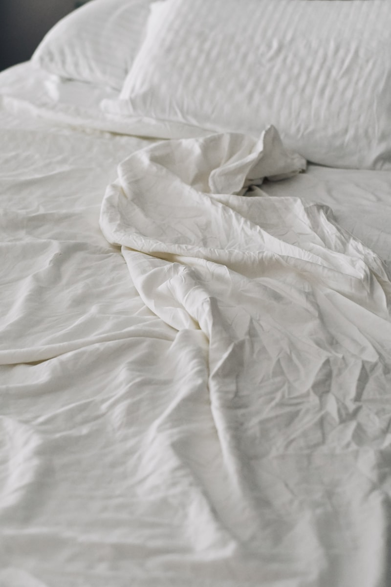 Lenzuola spiegazzate su un letto in luce morbida
