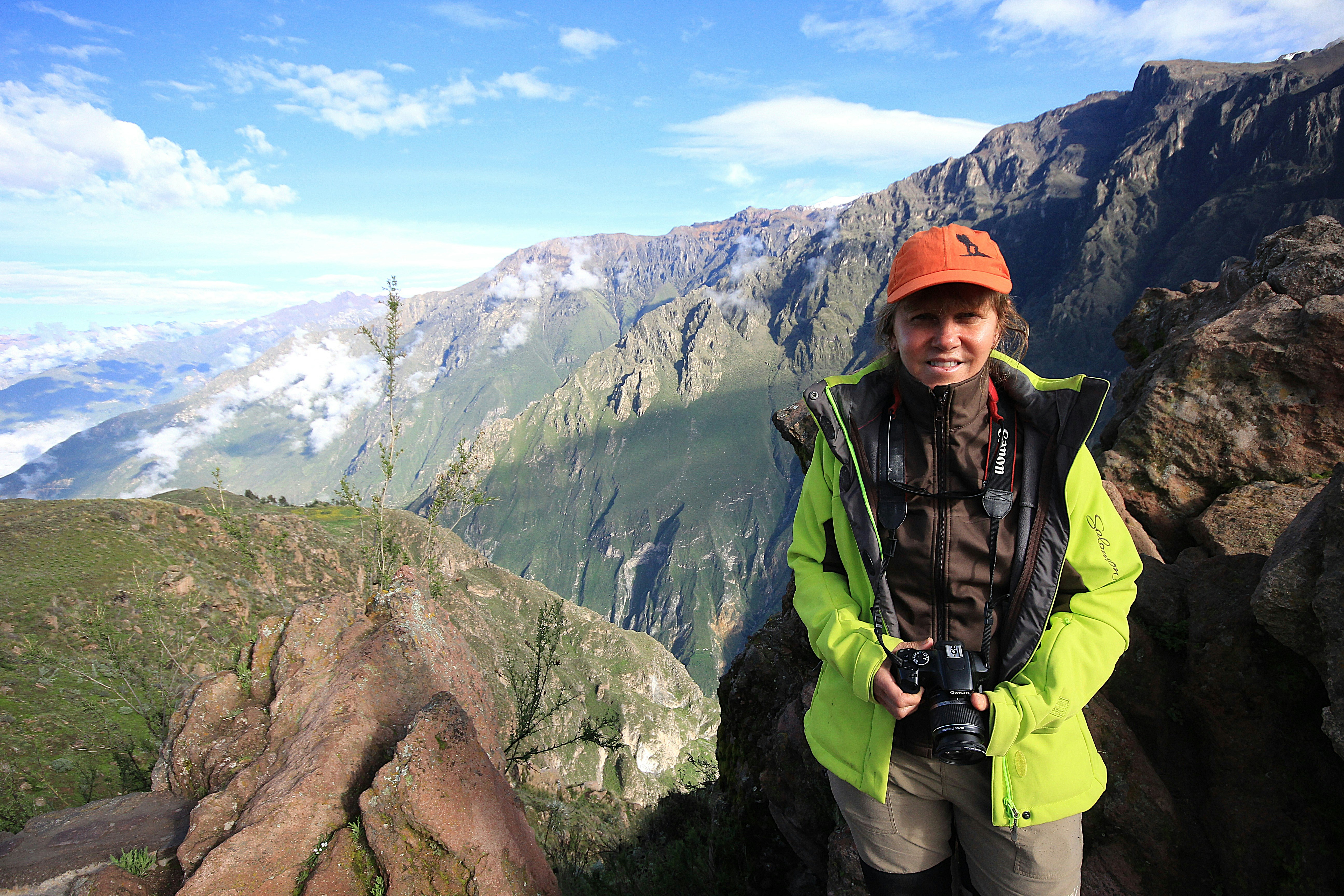 Woman with camera in mountainous landscape