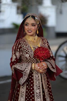 Bride in traditional red wedding attire holding flowers