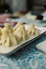 Plate of khinkali dumplings on a patterned tablecloth