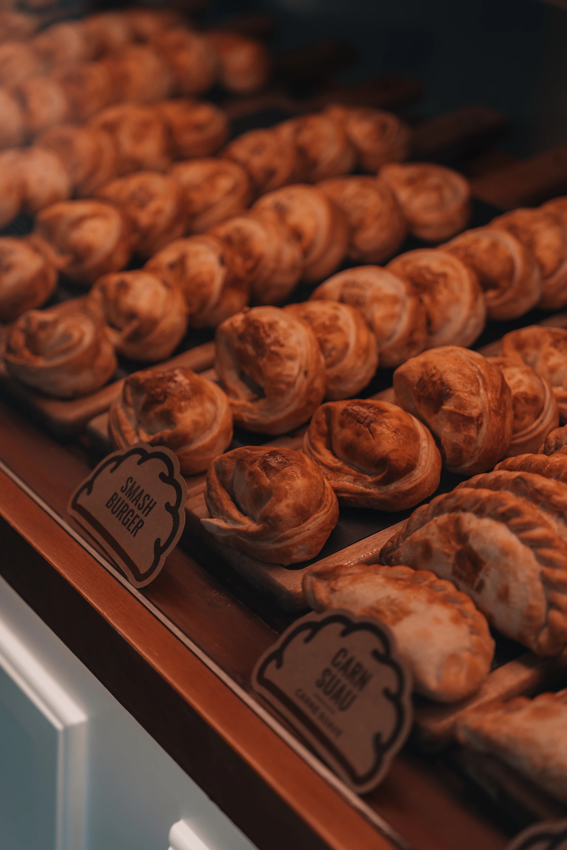Rows of golden baked pastries in a display case