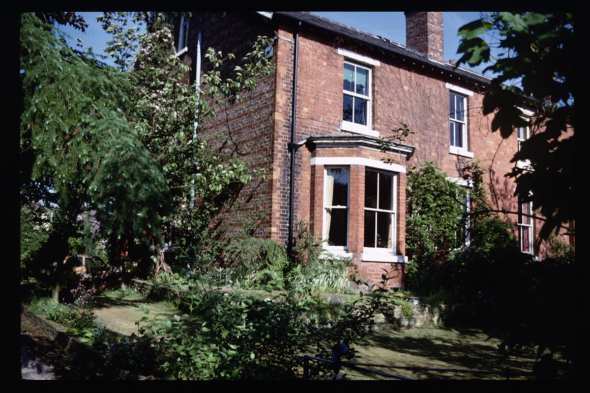 Red brick house with a front garden on a residential street