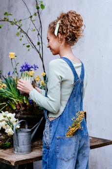 Woman arranging spring flowers with watering can