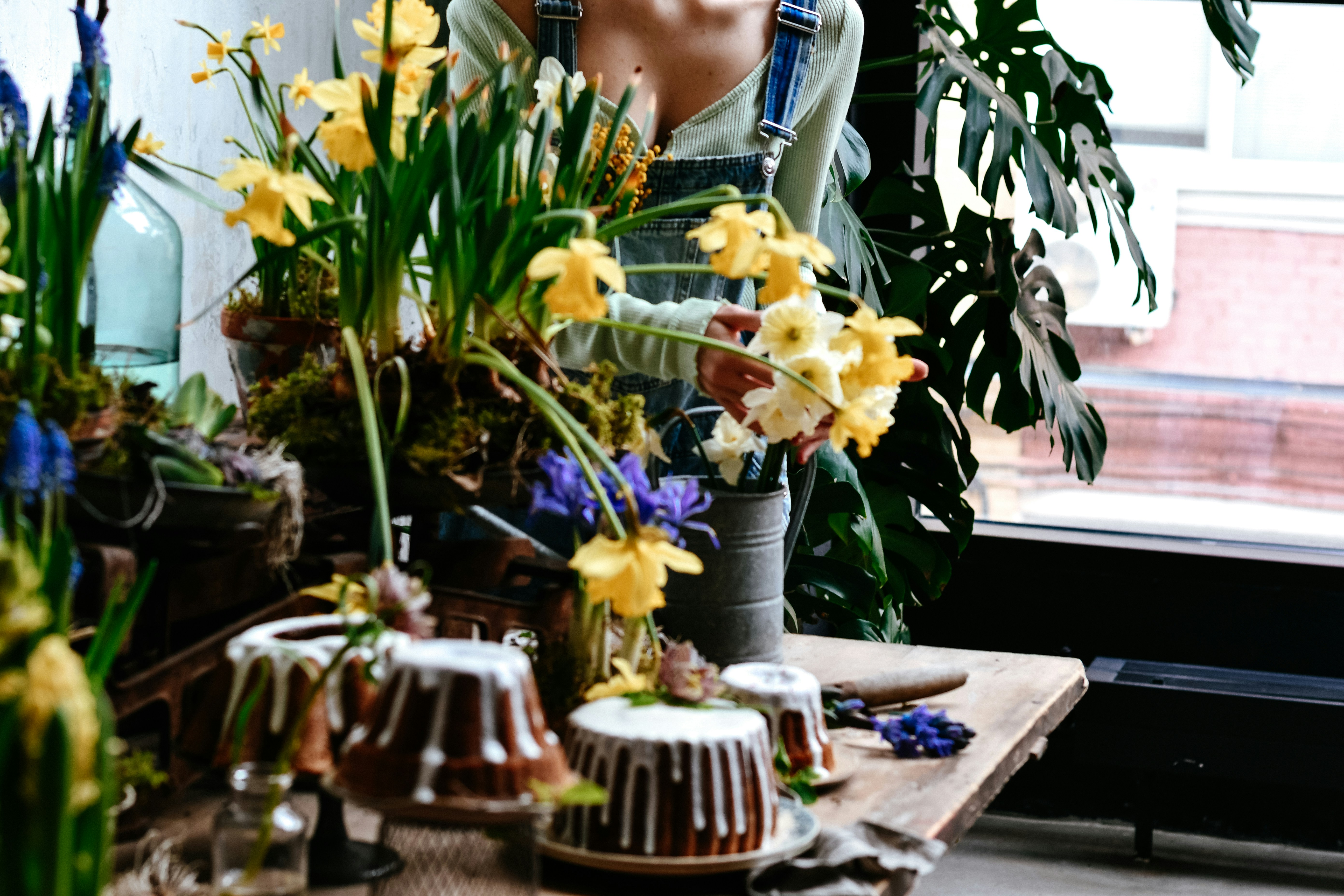 Woman arranging yellow daffodils and blue hyacinths
