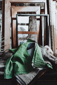Green linen draped over rustic frames and antique frames