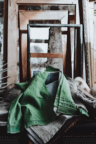 Green linen draped over rustic frames and antique frames