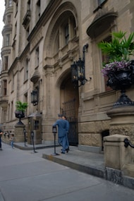 Doorman in uniform by ornate building entrance