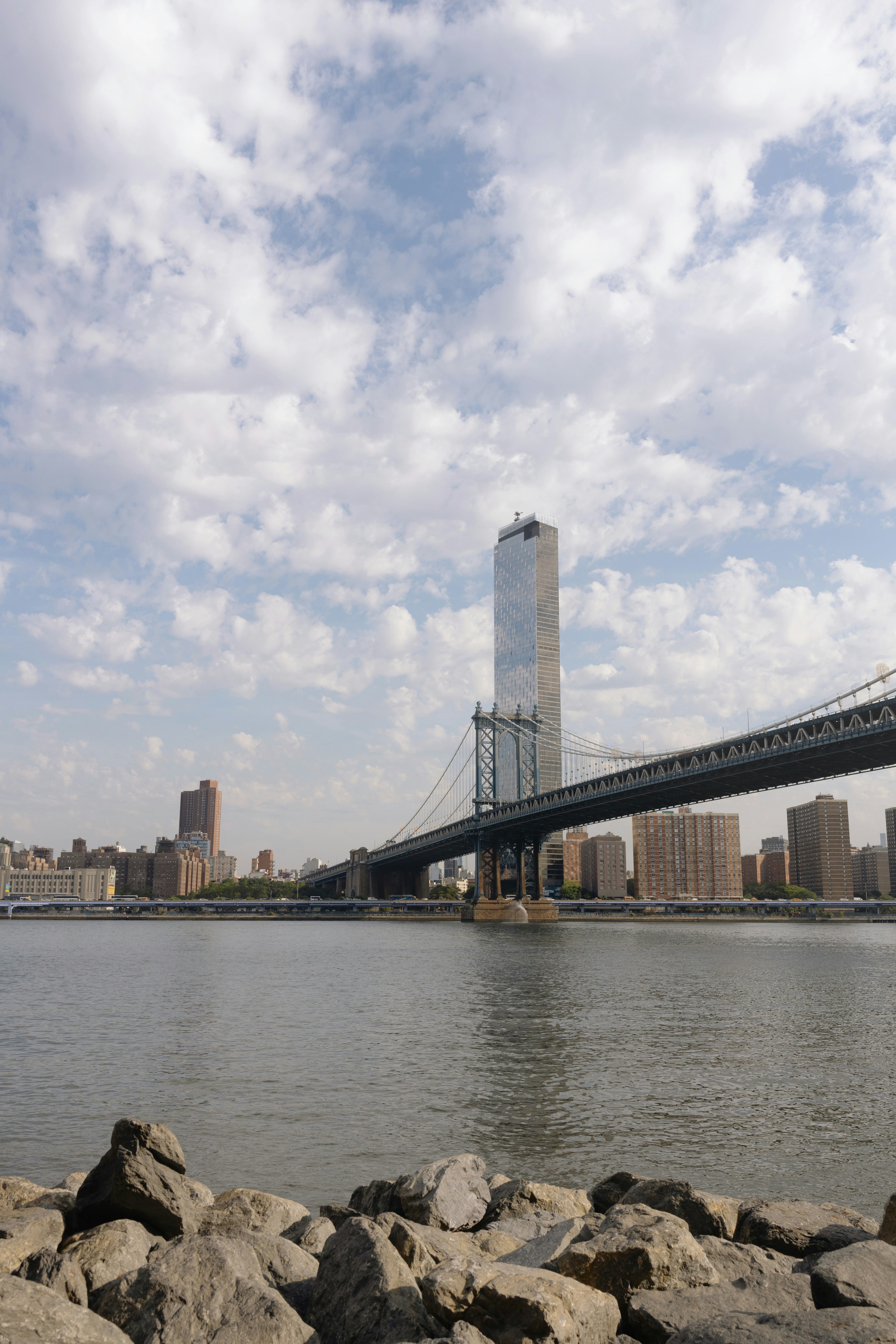Manhattan bridge and skyscrapers over calm water