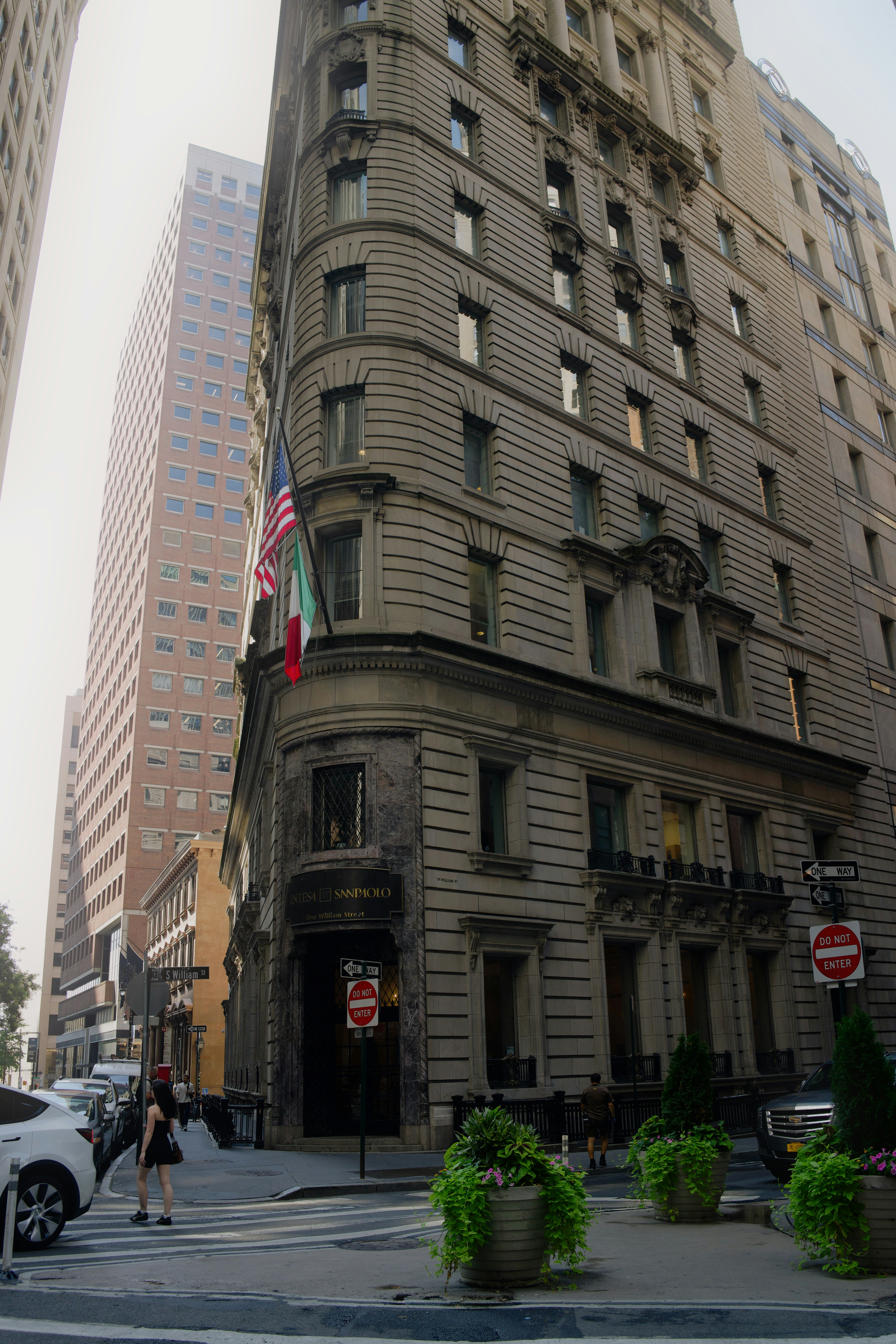 Ornate building corner with flags and city street.