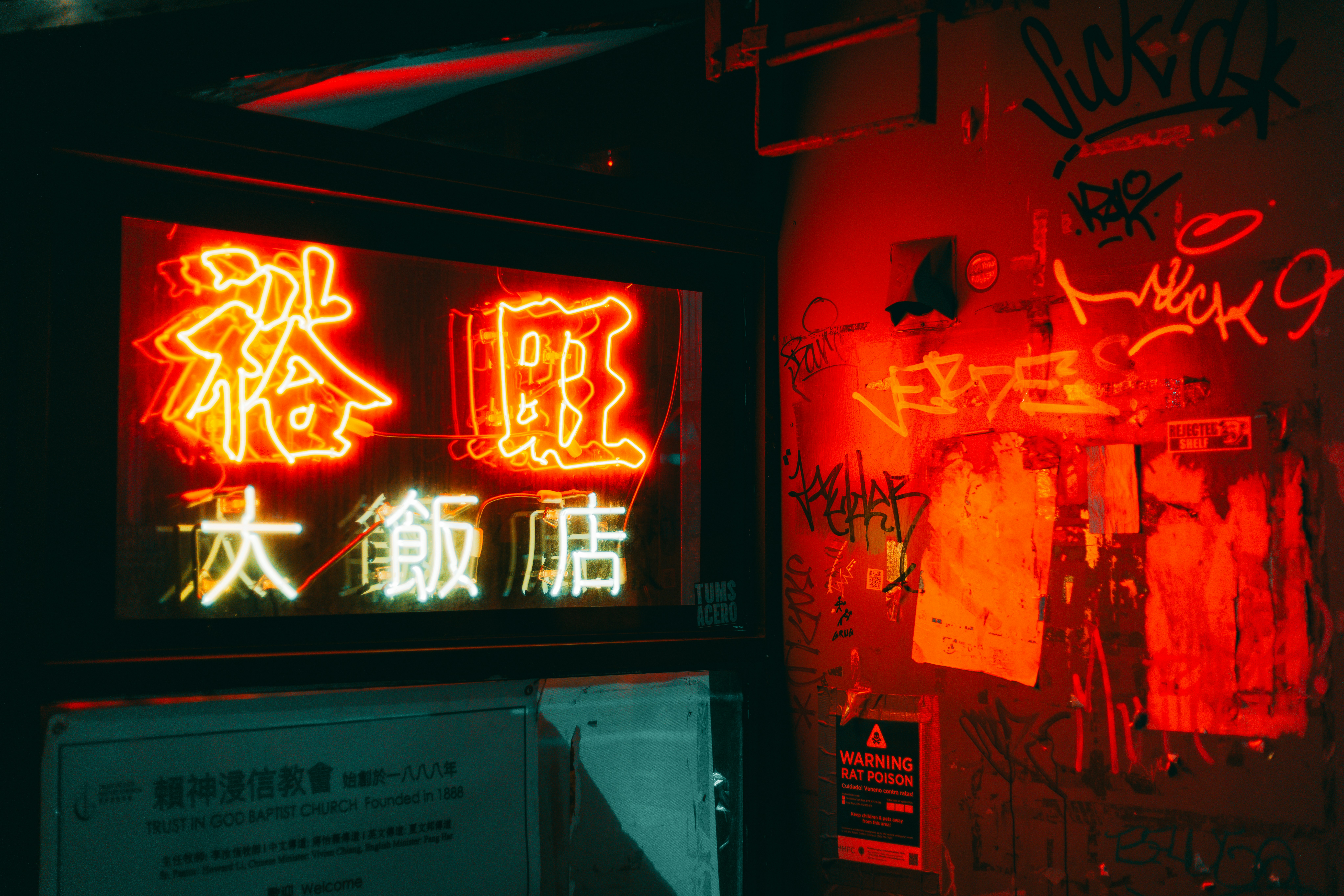 Neon sign in dark alley with graffiti