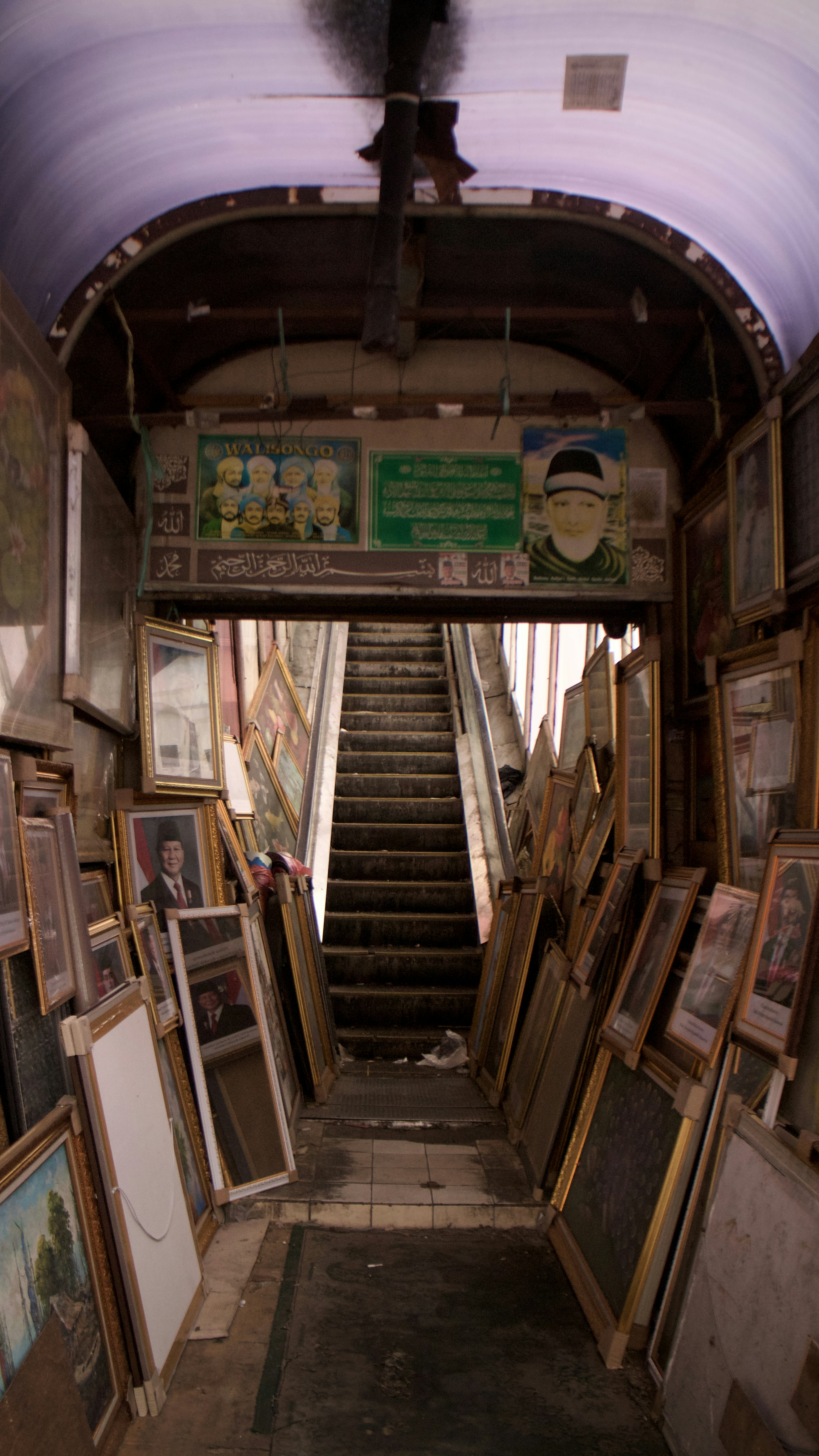 Framed pictures line a hallway leading to stairs.