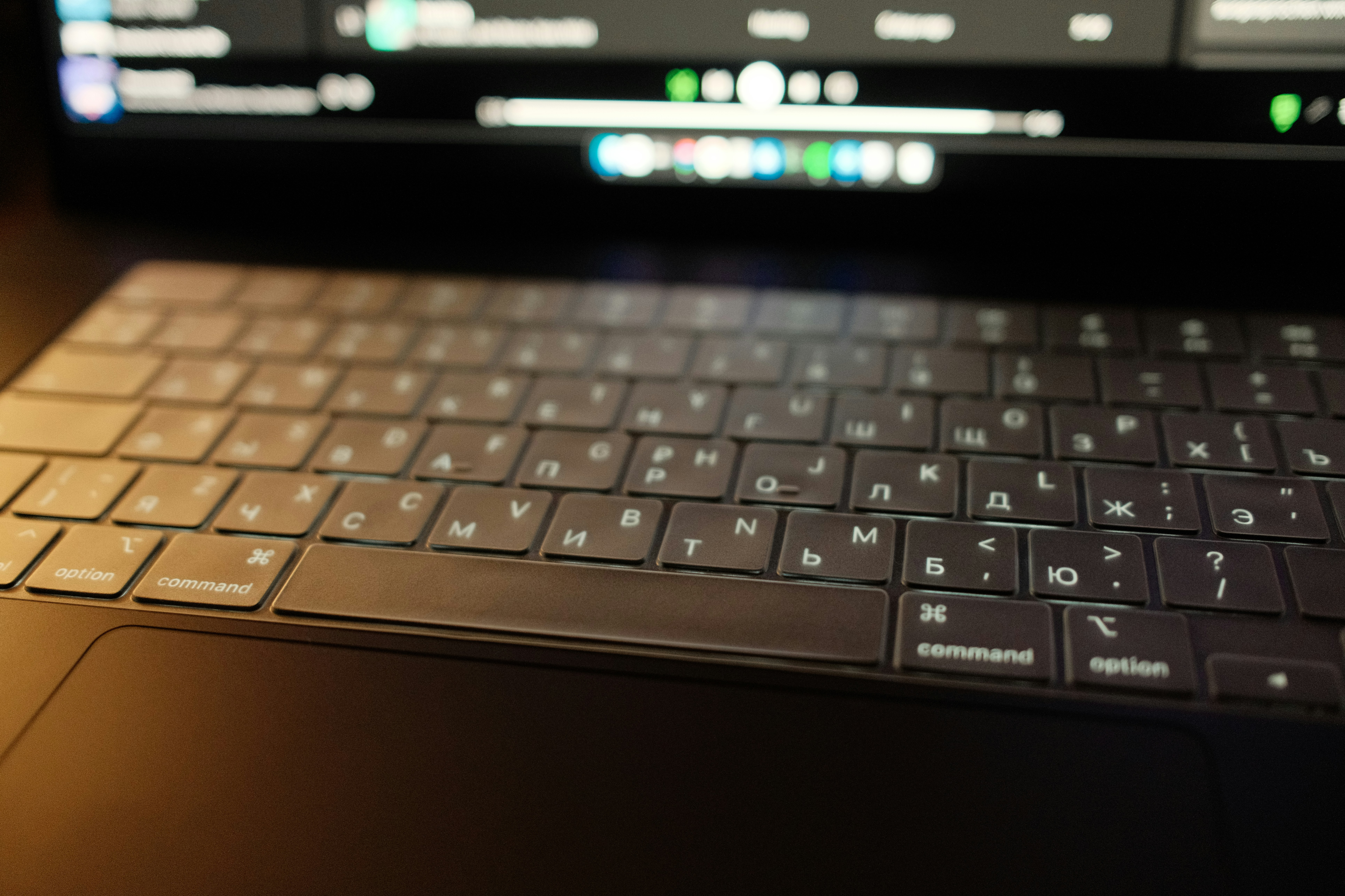 Close-up of a laptop keyboard with screen blurred