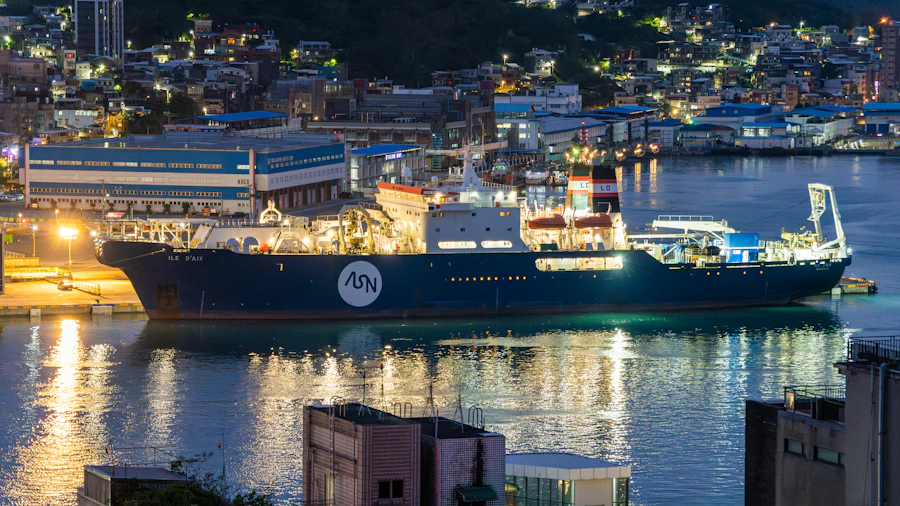 A research vessel lit up at its berth in a harbour at night