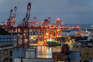 Industrial port with cranes and ships at dusk