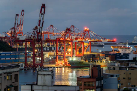 Industrial port with cranes and ships at dusk