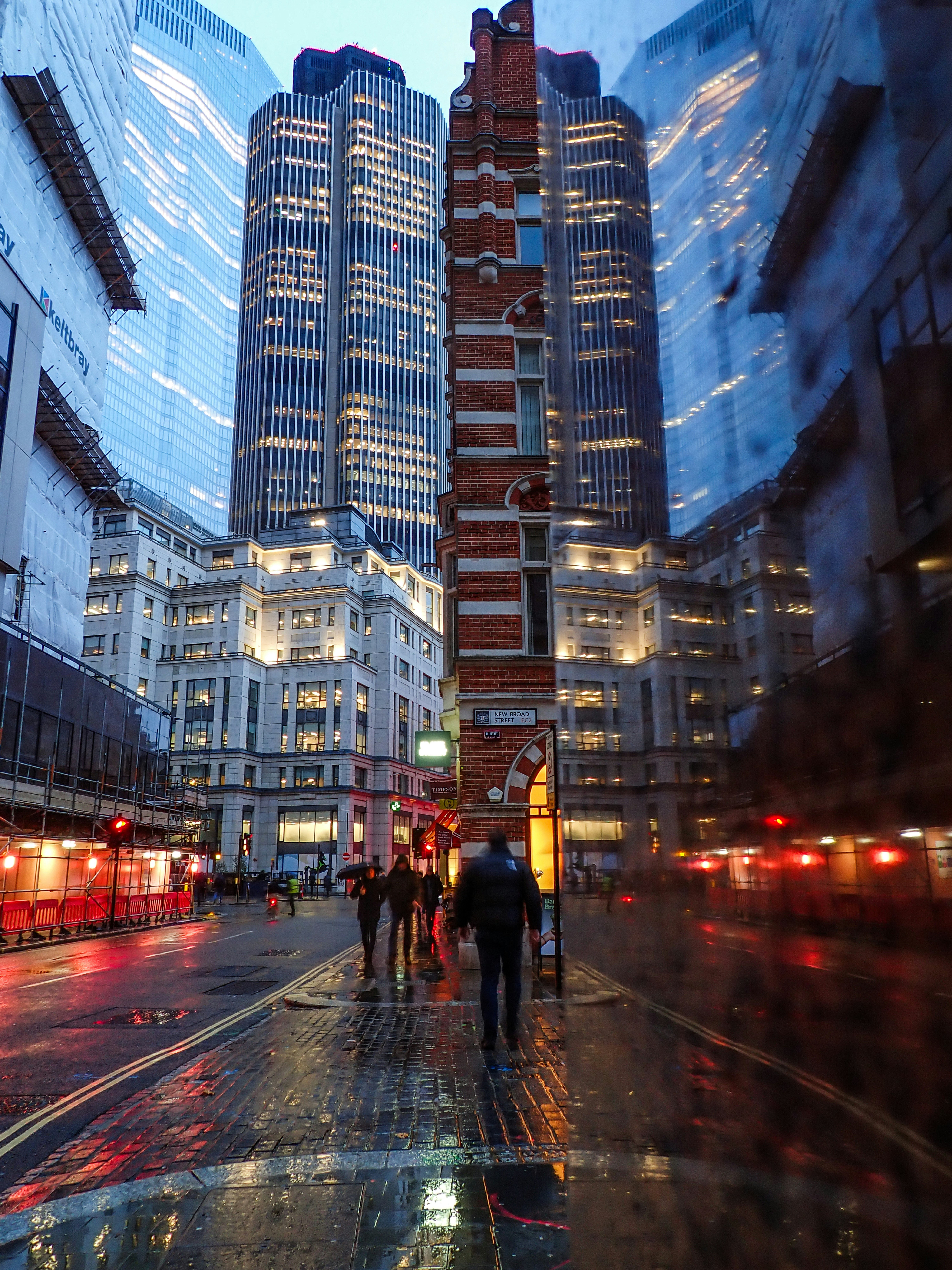City street with tall buildings and wet pavement